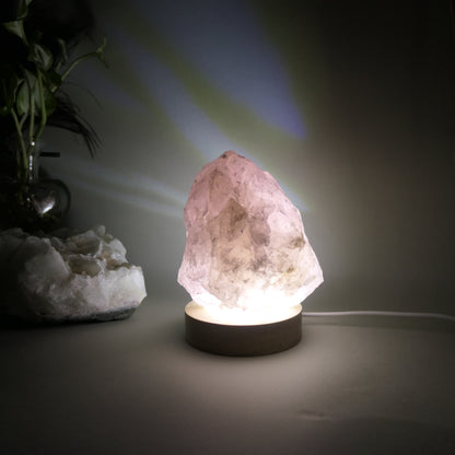 1kg Rose Quratz Cut base sitting on 8mm wooden LED white light base that is turned on
